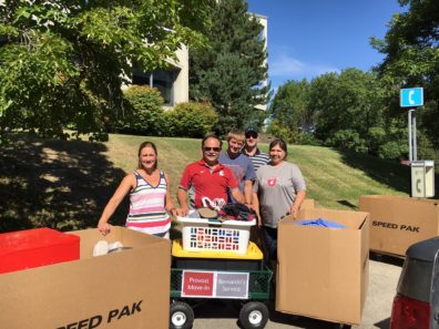 Provost Dan Bernardo, center in crimson, helps Cody and his family move into his residence hall during Move In 2016.